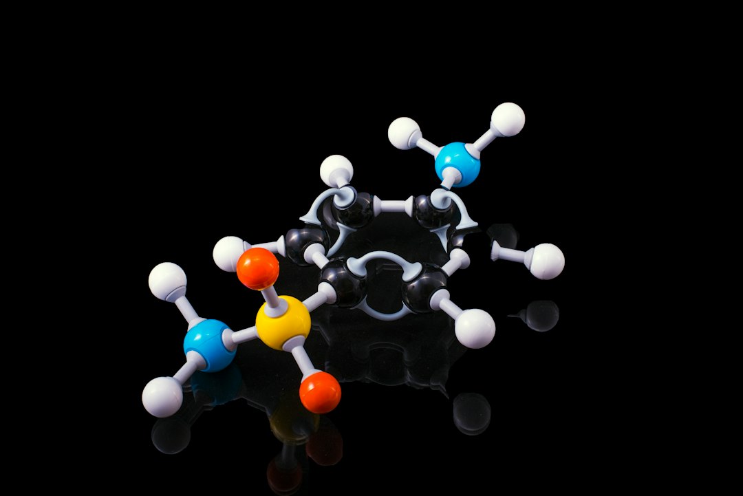 A molecular model of a peptide structure with colorful atoms connected by bonds on a black background.